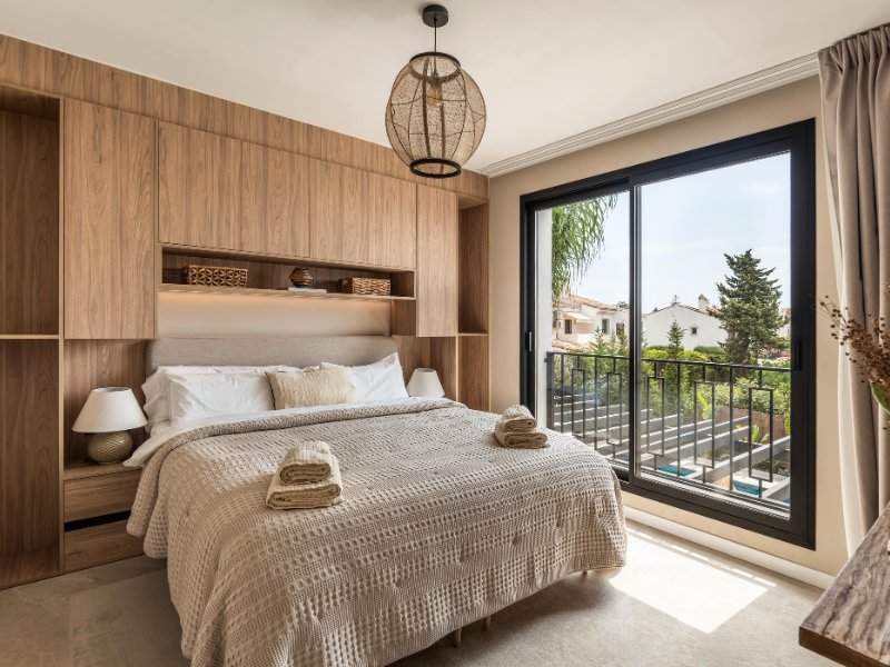 Cozy bedroom in a beach villa, just steps from the sea, featuring a serene design with soft, neutral tones, comfortable furnishings, and large windows that offer breathtaking ocean views, creating a peaceful retreat for relaxation.