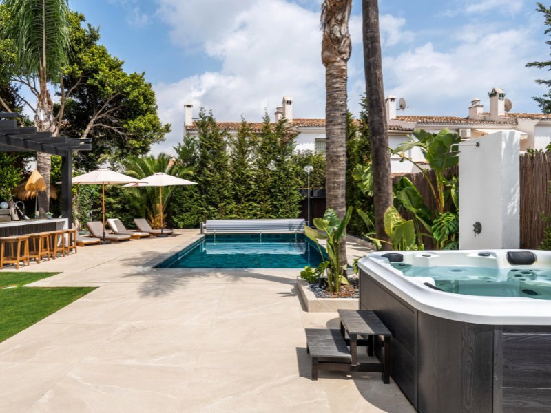Inviting hot tub in a cozy beach villa, just steps from the sea, surrounded by a private outdoor space with stunning ocean views, offering a relaxing and tranquil setting for unwinding and enjoying the coastal atmosphere.