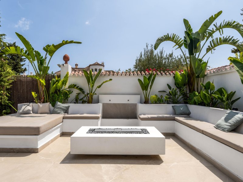 Private terrace of a cozy beach villa, just steps from the sea, offering comfortable outdoor seating, lush greenery, and breathtaking views of the ocean, creating a tranquil space to relax and enjoy the coastal breeze.