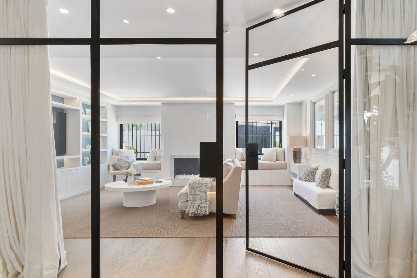 Sophisticated living room and entrance in a frontline golf villa in Nueva Andalucía, featuring elegant furnishings, large windows that flood the space with natural light, and a seamless flow into the home’s luxurious and welcoming atmosphere with views of the lush golf course.