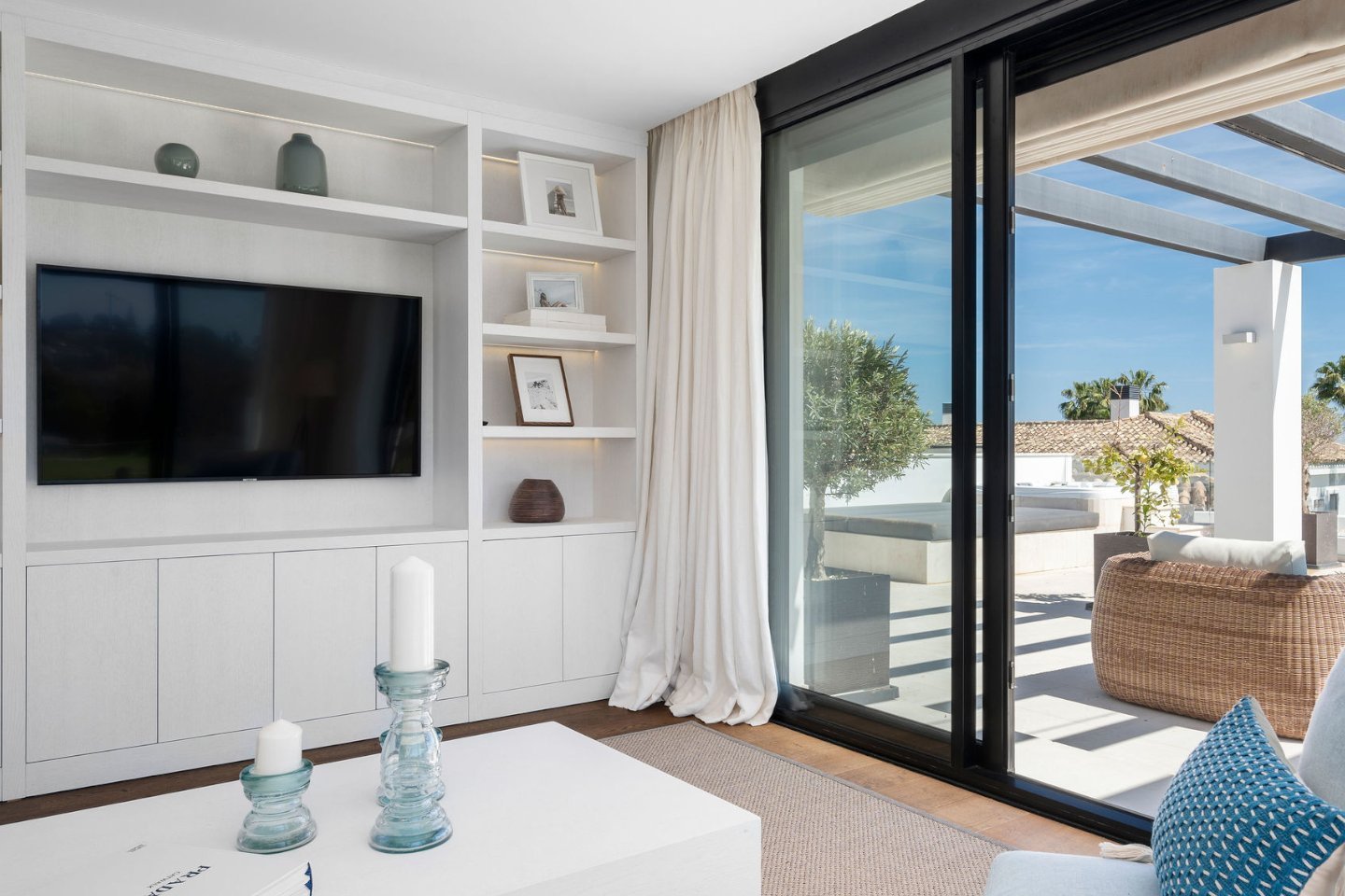 Elegant living room in a frontline golf villa in Nueva Andalucía, featuring contemporary furnishings, large windows that offer stunning views of the lush golf course, and a spacious, open layout designed for both relaxation and sophisticated entertaining.