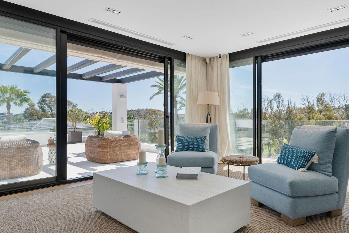 Spacious terrace in a frontline golf villa in Nueva Andalucía, offering luxurious outdoor living with comfortable seating, stylish design, and panoramic views of the lush golf course, creating an ideal space for relaxation and entertaining in a tranquil setting.
