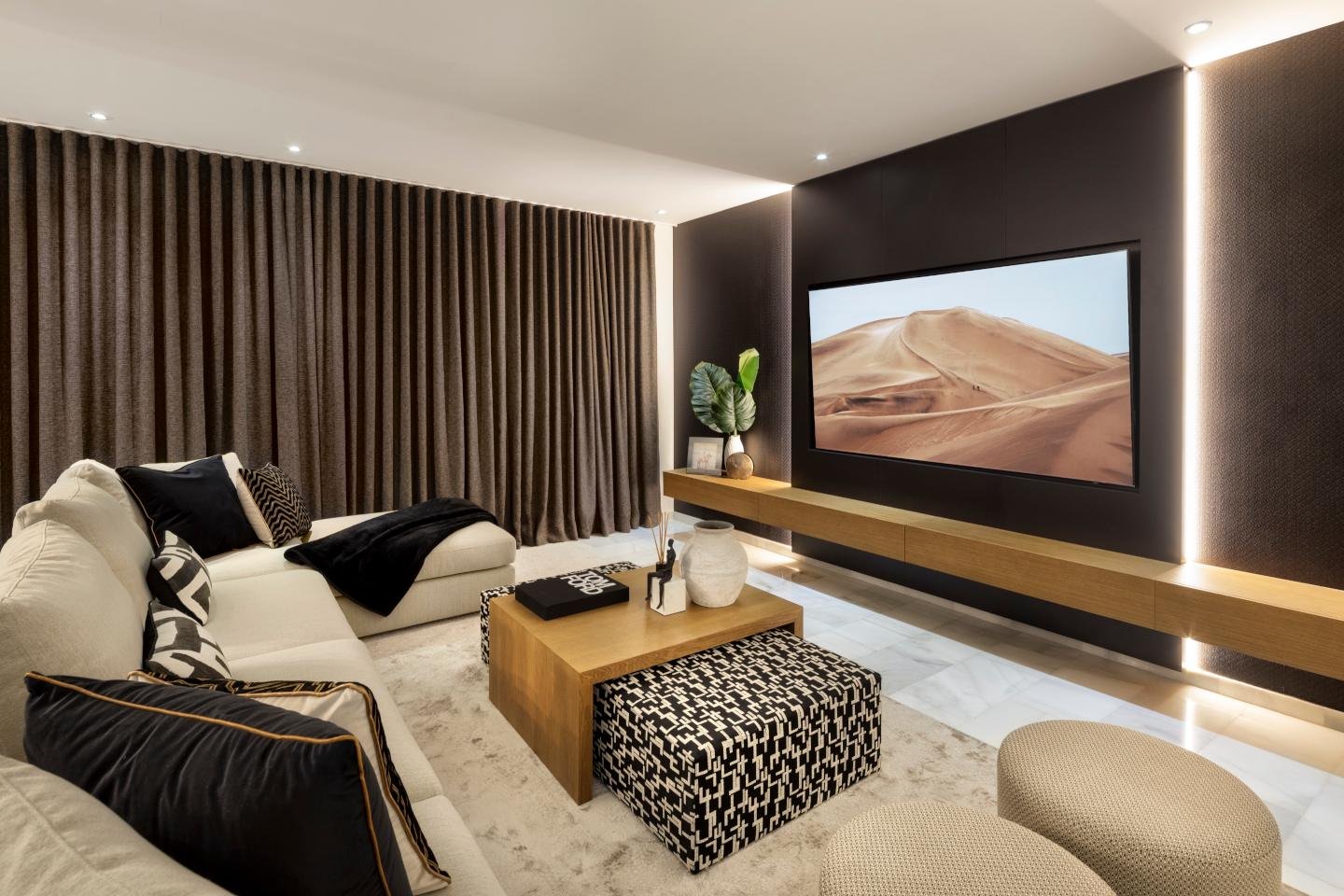 Grand TV room in a majestic Andalusian palace in Marbella, featuring opulent furnishings, intricate architectural details, and large windows that allow natural light to flood the space, creating a luxurious and inviting atmosphere for relaxation and entertainment.