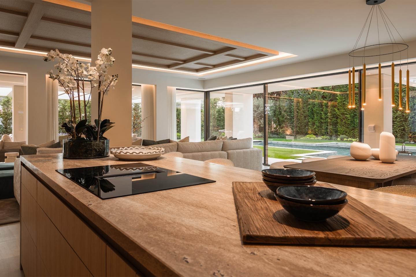 Sleek, modern kitchen in a luxury villa in Nueva Andalucía, featuring high-end appliances, a spacious central island, and contemporary cabinetry with clean lines. The open-plan design is enhanced by large windows, allowing natural light to illuminate the space, creating a perfect blend of functionality and style for cooking and entertaining.