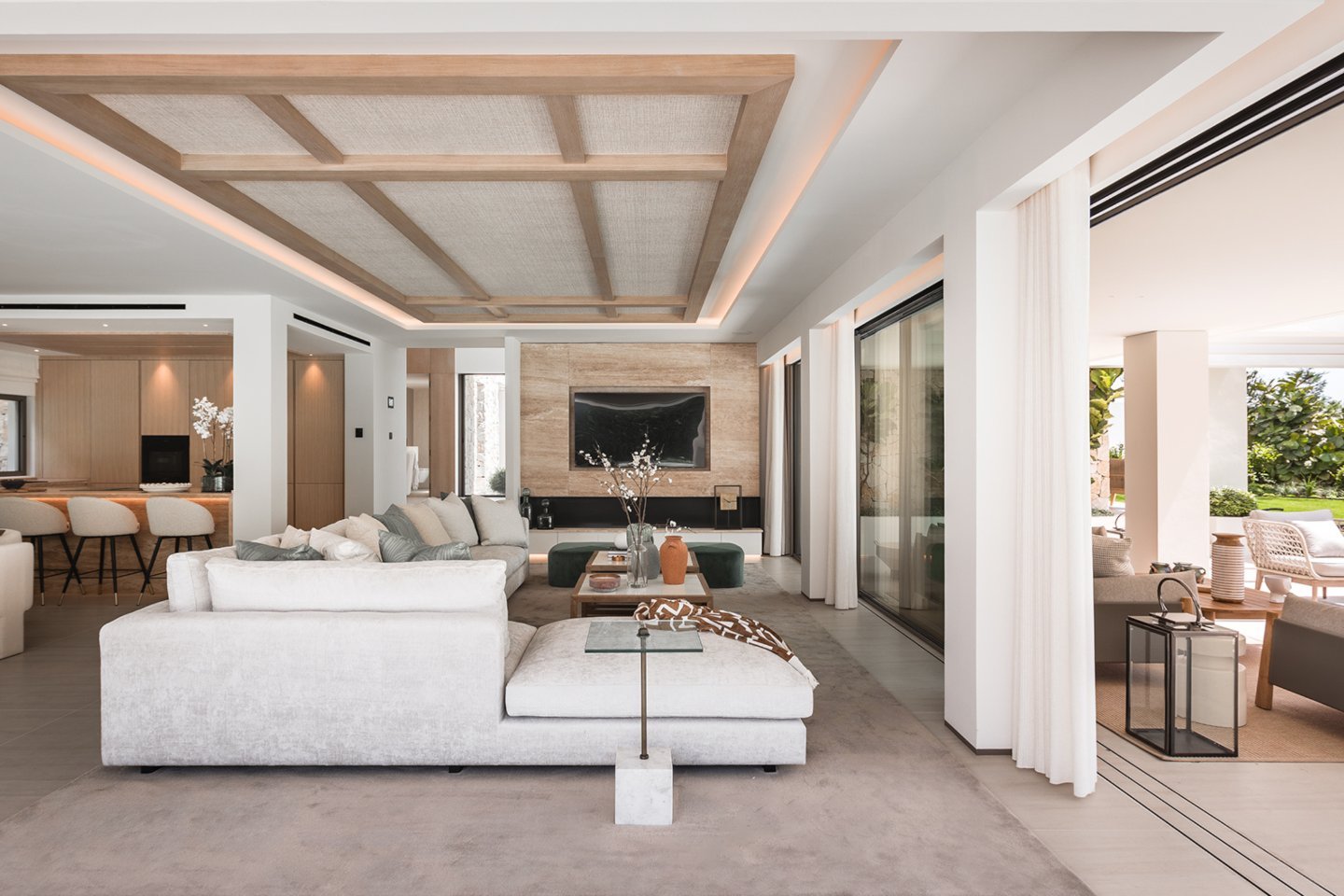 Contemporary living room in a modern villa in Nueva Andalucía, featuring stylish, minimalist furnishings, sleek design elements, and large windows that fill the space with natural light. The open, airy atmosphere blends luxury and comfort, with neutral tones and high-end finishes creating a sophisticated yet inviting setting for relaxation and entertaining.