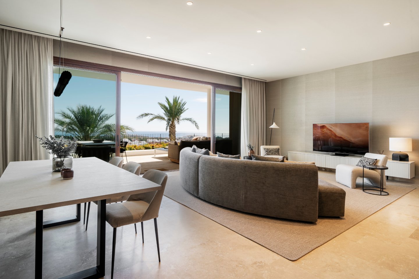 An elegant lounge area with contemporary furnishings, featuring a spacious open layout, plush seating, and floor-to-ceiling windows that fill the space with natural light. The modern decor, warm neutral tones, and subtle lighting create a sophisticated yet inviting atmosphere.