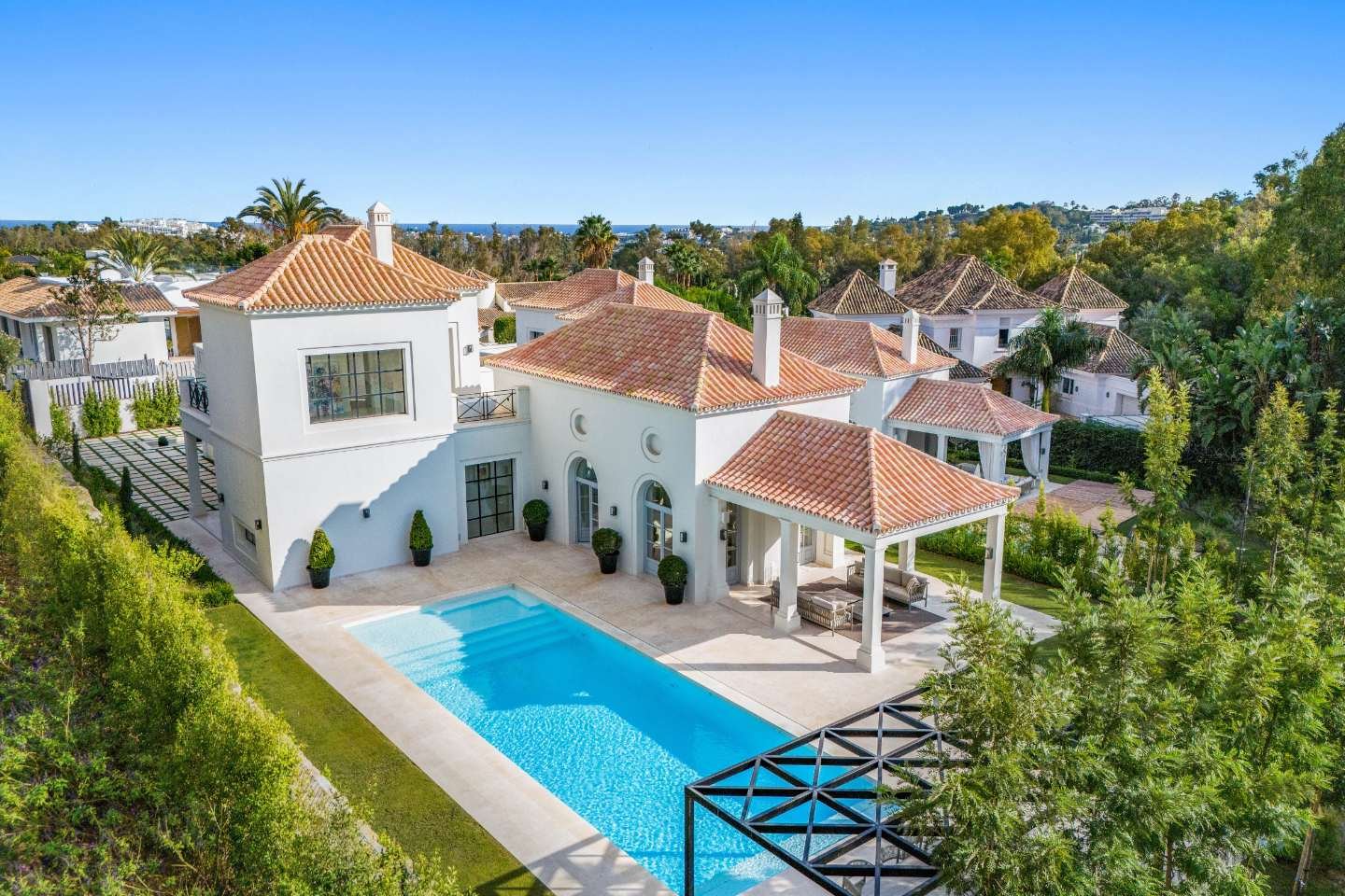 Elegant facade of a refined villa in Nueva Andalucía, where luxury meets Provençal charm. The villa features traditional architectural details combined with modern design elements, offering a harmonious blend of rustic and contemporary aesthetics. Surrounded by lush greenery, the exterior exudes warmth and sophistication, creating a welcoming atmosphere in a serene, upscale setting.