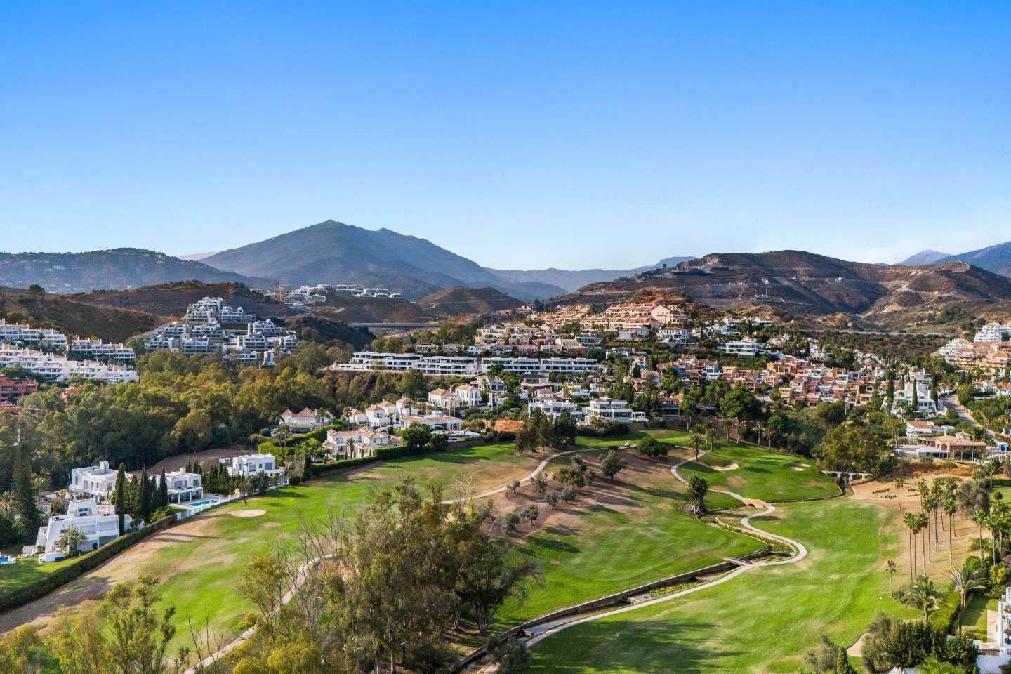 Breathtaking view from a refined villa in Nueva Andalucía, where luxury meets Provençal charm, overlooking a lush golf course. The expansive outdoor space features manicured gardens, a serene atmosphere, and a seamless connection to the natural beauty of the surrounding landscape. The villa offers the perfect setting for enjoying peaceful moments while surrounded by elegance and tranquility.