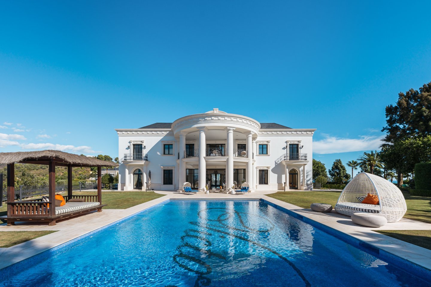Stunning facade of a luxury villa in Las Chapas, Marbella, showcasing elegant architectural design with clean lines, large windows, and a harmonious blend of modern and classic elements. Surrounded by lush greenery, the villa exudes timeless elegance and exclusivity, offering a perfect balance of sophistication and natural beauty.