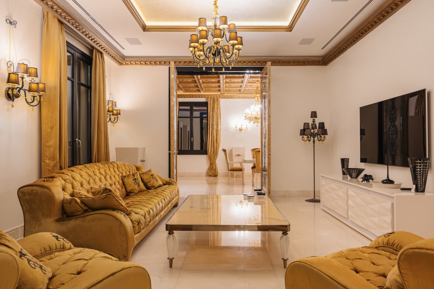 Spacious living room in a luxury villa in Las Chapas, Marbella, featuring elegant contemporary furnishings, soft neutral tones, and large windows that fill the space with natural light. The sophisticated design blends timeless elegance with modern comfort, creating an inviting atmosphere perfect for relaxation and entertaining.